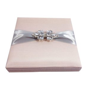 Blush pink wedding invitation box with brooch