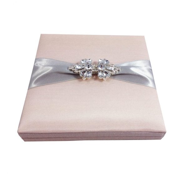 Blush pink wedding invitation box with brooch