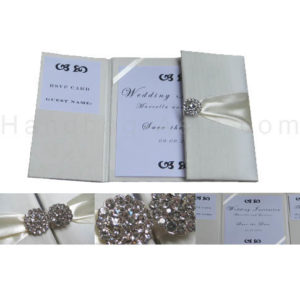 Embellished ivory wedding invitations with brooches