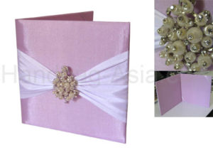Pink wedding folder with pearl brooch and ribbon embellishment