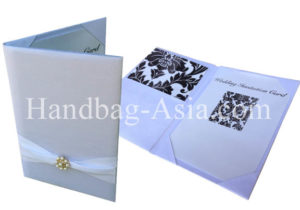 white silk pocket fold with pearl brooch for invitation cards