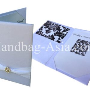 white silk pocket fold with pearl brooch for invitation cards