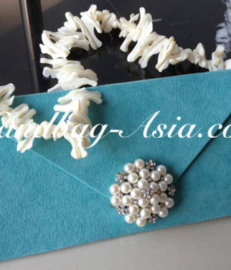 embellished evening clutch bag with pearl brooch