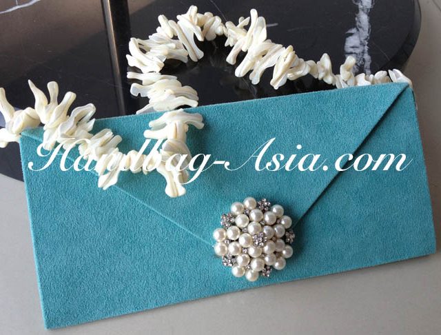 embellished evening clutch bag with pearl brooch