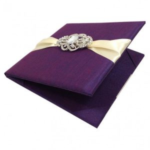 Egglant color silk invitation folio with ivory ribbon and vintage brooch embellishment