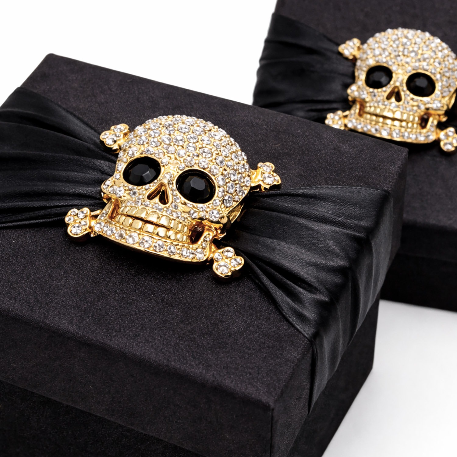 Close up rhinestone skull brooch on silk box