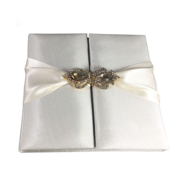 Silk covered invitation box with crown brooches in ivory