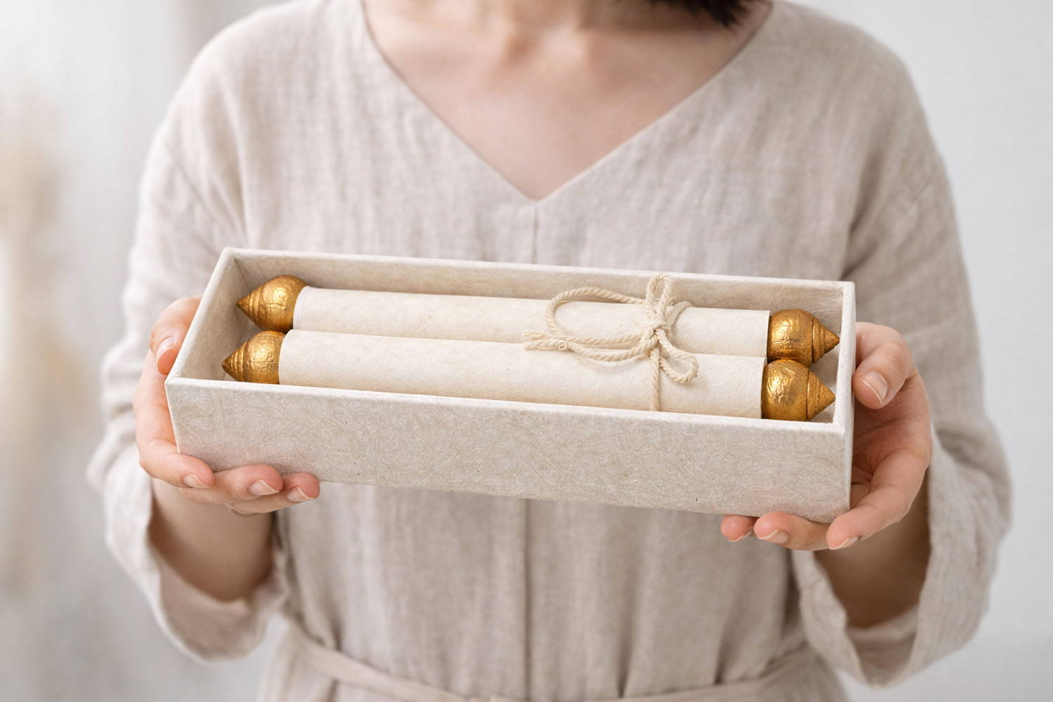 Women holding our handmade mulberry paper scroll invitation set in Chiang Mai, Thailand.