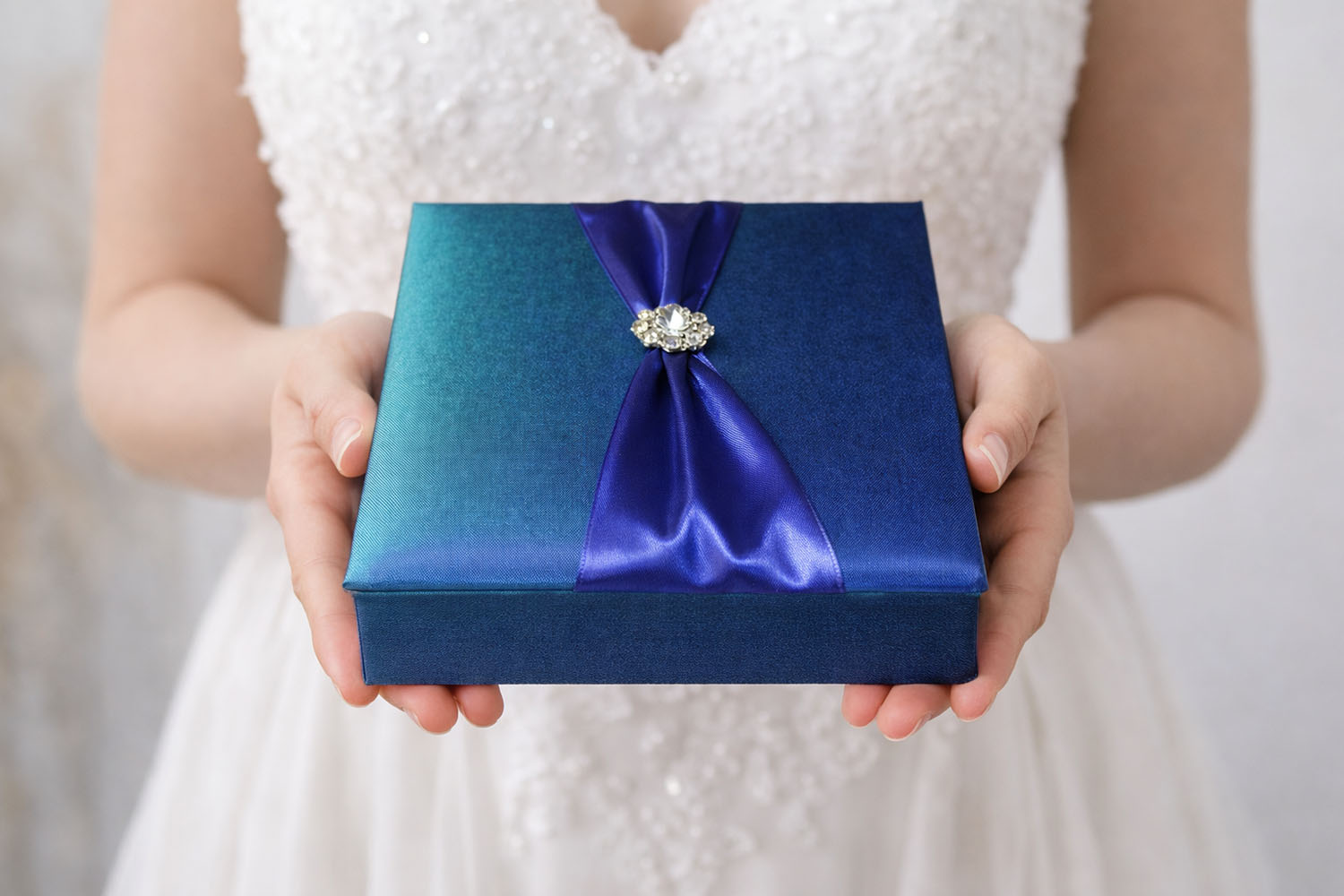 Handmade turquoise Thai silk wedding invitation box with timeless brooch embellishment