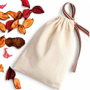 Natural cotton canvas drawstring packaging bag with striped ribbon closure on white background.