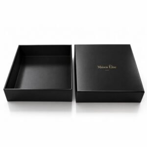 Luxury black rigid box with metallic gold foil-stamped logo and removable lift-off lid for premium gift packaging.