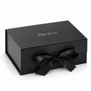 Luxury matte black rigid gift box with Élise & Co. gold foil stamped logo and black grosgrain ribbon