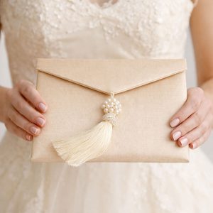 Champagne silk envelope with pearl brooch and tassel embellishment